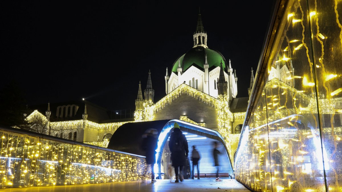 People walk on a bridge near the Academy of Fine Arts, decorated with lights for upcoming holidays, Sarajevo, Bosnia-Herzegovina, Dec. 21, 2025. (Reuters Photo)