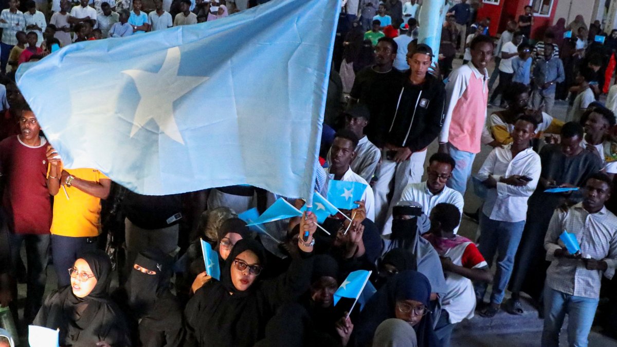 A woman holds a large Somali flag as Somalis attend a demonstration against Israel's recognition of the self-declared Republic of Somaliland as an independent and sovereign state, in Mogadishu, Somalia, Dec. 28, 2025. (Reuters Photo)