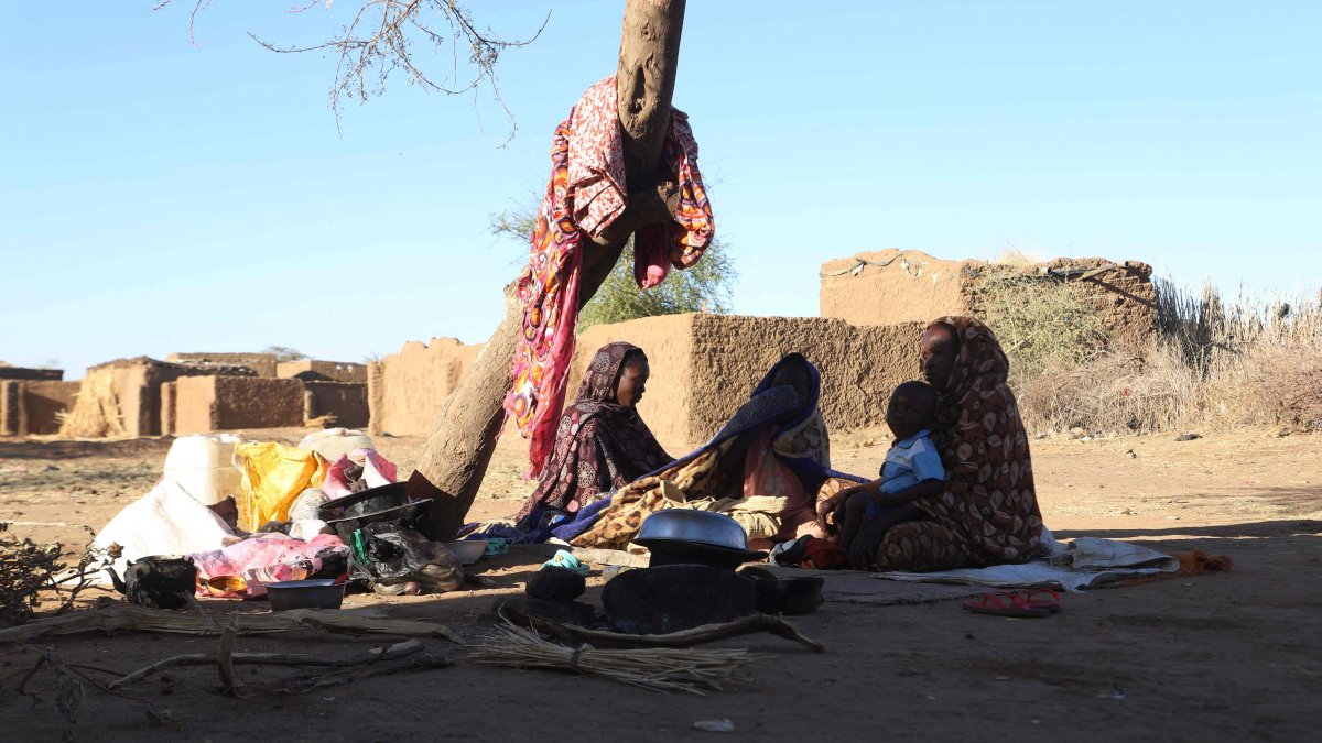 Sudanese displaced people who left el-Fasher after its fall, sit in the shade in Tawila, Sudan, Dec. 17, 2025. (AFP Photo)
