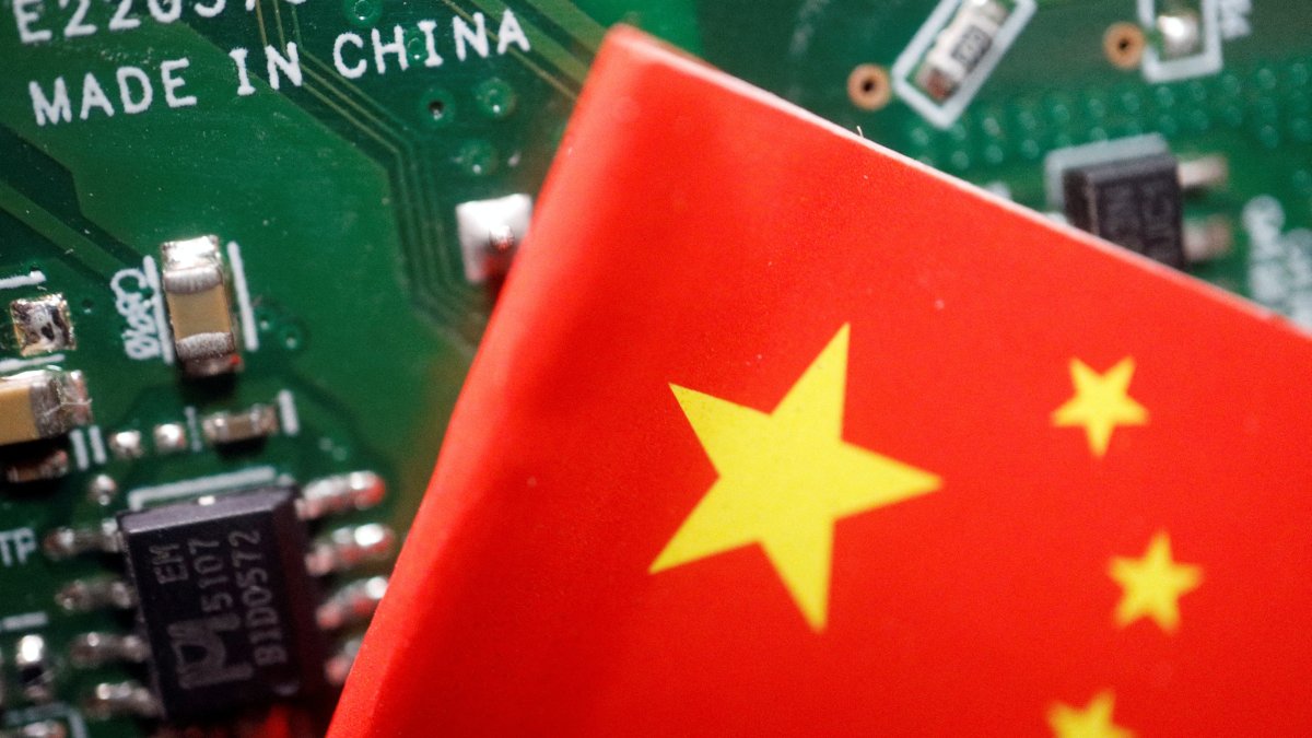 A Chinese flag is displayed next to a "Made in China" sign seen on a printed circuit board with semiconductor chips, in this illustration picture taken Feb. 17, 2023. (Reuters Photo)