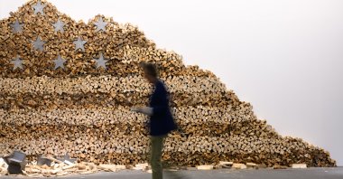 A visitor walks next to an artwork of Danh Vo, "In God We Trust" 2020, displayed at Art Basel at Messe Basel, Basel, Switzerland, June 17, 2025. (Getty Images Photo)