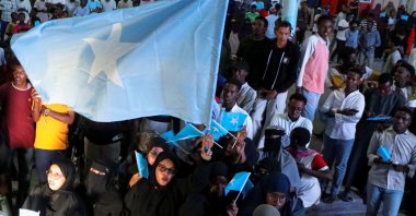 A woman holds a large Somali flag as Somalis attend a demonstration against Israel's recognition of the self-declared Republic of Somaliland as an independent and sovereign state, in Mogadishu, Somalia, Dec. 28, 2025. (Reuters Photo)