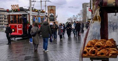 A street vendor sells traditional Turkish bagels, "simit," as he waits for customers at Taksim Square, Istanbul, Türkiye, Dec. 27, 2025. (AFP Photo)