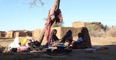 Sudanese displaced people who left el-Fasher after its fall, sit in the shade in Tawila, Sudan, Dec. 17, 2025. (AFP Photo)