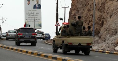 Southern forces ride a vehicle driving past a banner depicting UAE President Sheikh Mohammed bin Zayed Al Nahyan (L) and the top leader of the UAE-backed Southern Transitional Council (STC), Aidaros Alzubidi, in the southern port city of Aden, Yemen, Dec. 30, 2025. (EPA Photo)
