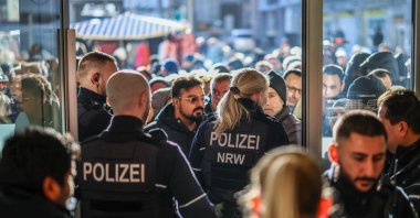 Policemen and concerned bank customers stand in front of a branch of the Sparkasse bank in Gelsenkirchen, western Germany, Dec. 30, 2025. (AFP Photo)