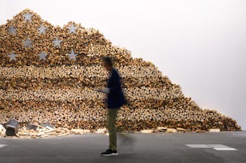 A visitor walks next to an artwork of Danh Vo, "In God We Trust" 2020, displayed at Art Basel at Messe Basel, Basel, Switzerland, June 17, 2025. (Getty Images Photo)