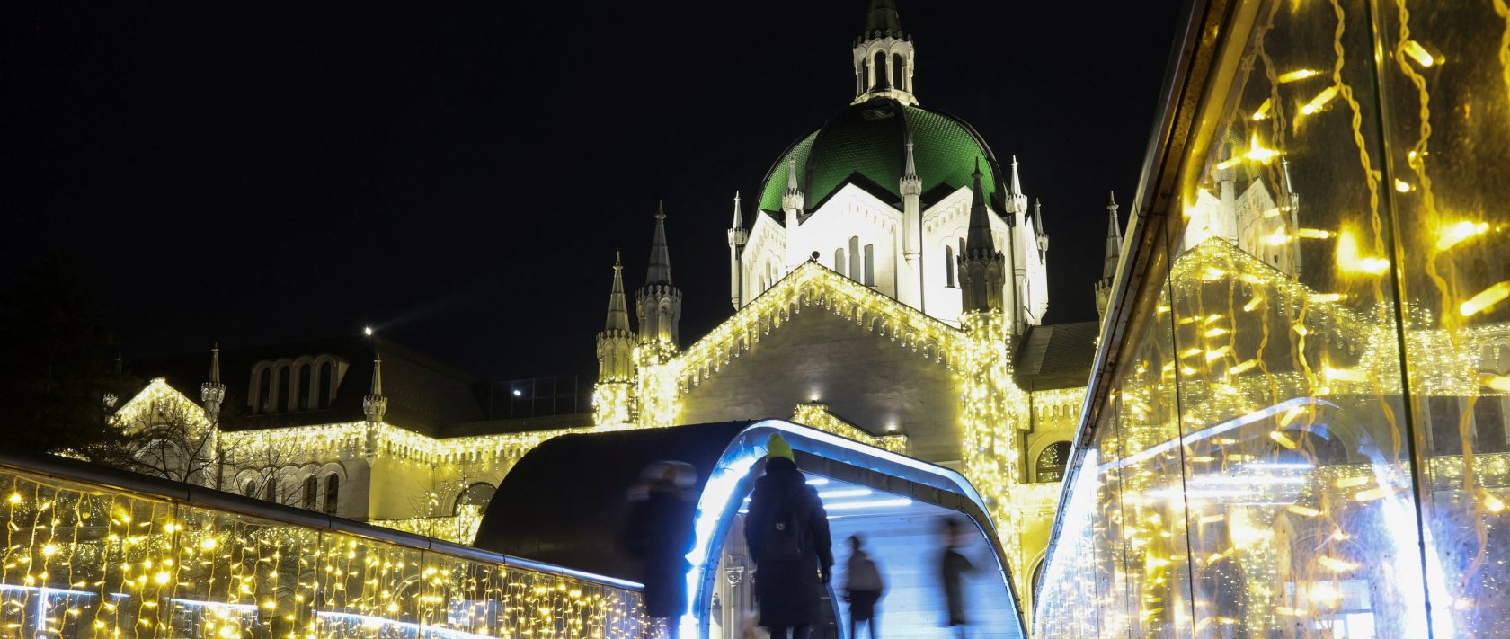 People walk on a bridge near the Academy of Fine Arts, decorated with lights for upcoming holidays, Sarajevo, Bosnia-Herzegovina, Dec. 21, 2025. (Reuters Photo)