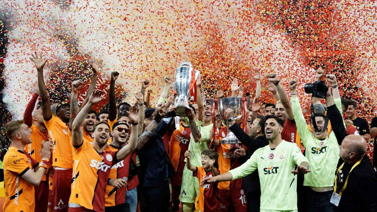 Galatasaray players celebrate on the pitch after clinching both the Süper Lig and Ziraat Türkiye Cup trophies during the championship ceremony, Istanbul, Türkiye, May 25, 2025. (IHA Photo)