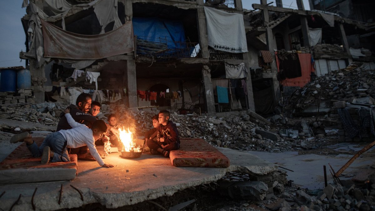 Displaced Palestinians warm themselves near a fire among the ruins of their destroyed home, Khan Yunis, Gaza Strip, Palestine, Dec. 30, 2025. (EPA Photo)