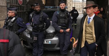 Pedro Elias Garzon Delvaux (R) walks past as police officers block an entrance to the Louvre after thieves carried out a daylight raid on French crown jewels, Paris, France, Oct. 19, 2025. (AP Photo)
