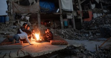 Displaced Palestinians warm themselves near a fire among the ruins of their destroyed home, Khan Yunis, Gaza Strip, Palestine, Dec. 30, 2025. (EPA Photo)