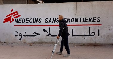 A Palestinian man walks on his crutches to the Doctors Without Borders (MSF) clinic, in the al-Rimal neighborhood of Gaza City on New Year's Eve, Dec. 31, 2025. (AFP Photo)