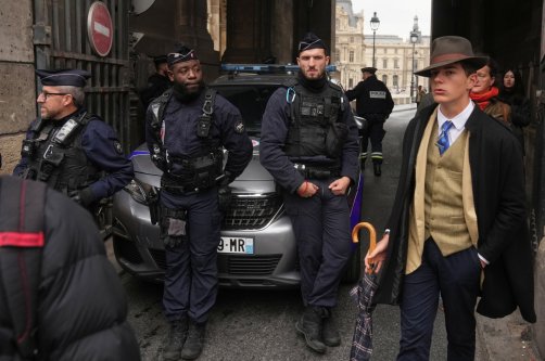 Pedro Elias Garzon Delvaux (R) walks past as police officers block an entrance to the Louvre after thieves carried out a daylight raid on French crown jewels, Paris, France, Oct. 19, 2025. (AP Photo)