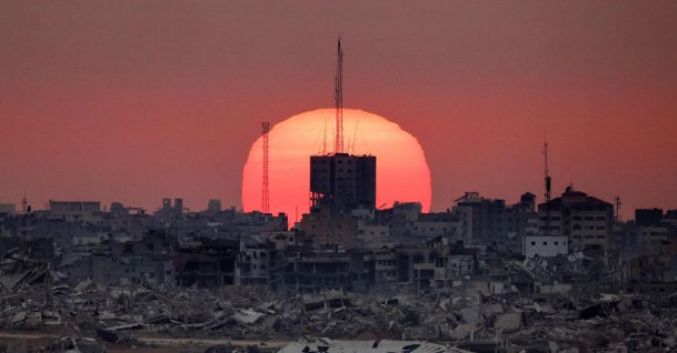The sun sets behind destroyed buildings in the Gaza Strip, Israel-Palestine border, July 1, 2025. (AFP Photo)
