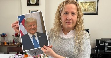 Necla Özmen poses with a photo of U.S. President Donald Trump during an interview with DHA at her home in the capital Ankara, Türkiye, Dec. 31, 2025. (DHA Photo)