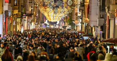 Pedestrians walk along Istiklal Street decorated with light ornaments, Istanbul, Türkiye, Dec. 31, 2025. (AFP Photo)