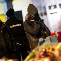 A mourner gestures in front of flowers and candles laid near the site where a fire ripped through a crowded bar during New Year's Eve celebrations in the Alpine ski resort town of Crans-Montana, Switzerland, Jan. 1, 2026. (AFP Photo)