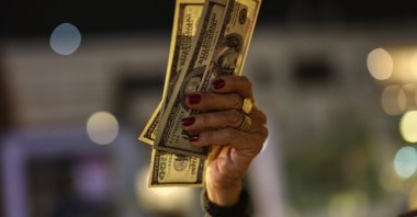 A demonstrator holds up U.S. dollar bills during a protest against Israeli Prime Minister Benjamin Netanyahu's government, Tel Aviv, Israel, Dec. 20, 2025. (Reuters Photo)