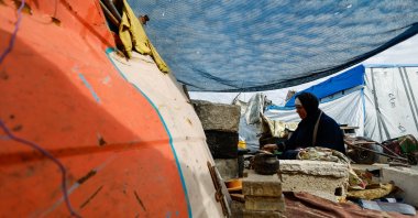 A displaced Palestinian woman cooks at a tent, on New Year's Eve in Jabalia, northern Gaza Strip, Dec. 31, 2025. (Reuters Photo)