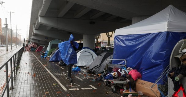 A migrant walks by a makeshift settlement where migrants evicted from a former high school last week are camping outdoors in the middle of winter in Badalona, Spain, Dec. 26, 2025. (Reuters Photo)