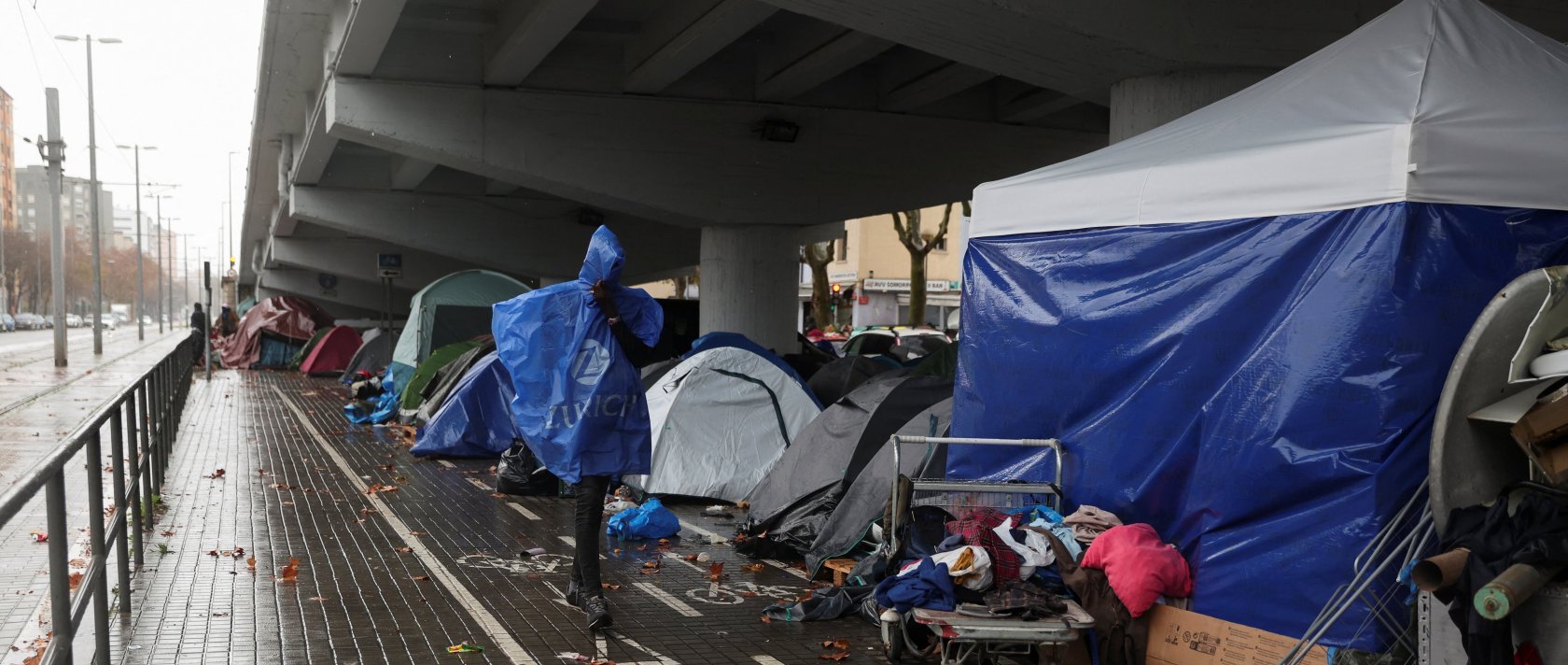 A migrant walks by a makeshift settlement where migrants evicted from a former high school last week are camping outdoors in the middle of winter in Badalona, Spain, Dec. 26, 2025. (Reuters Photo)