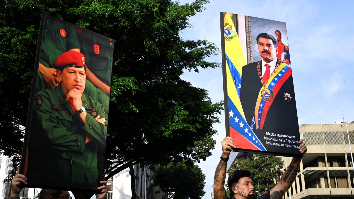 Government supporters hold photographs of Venezuela's late President Hugo Chavez and President Nicolas Maduro, after U.S. President Donald Trump said the U.S. has struck Venezuela and captured Maduro, in Caracas, Venezuela, Jan. 3, 2026. (Reuters Photo)