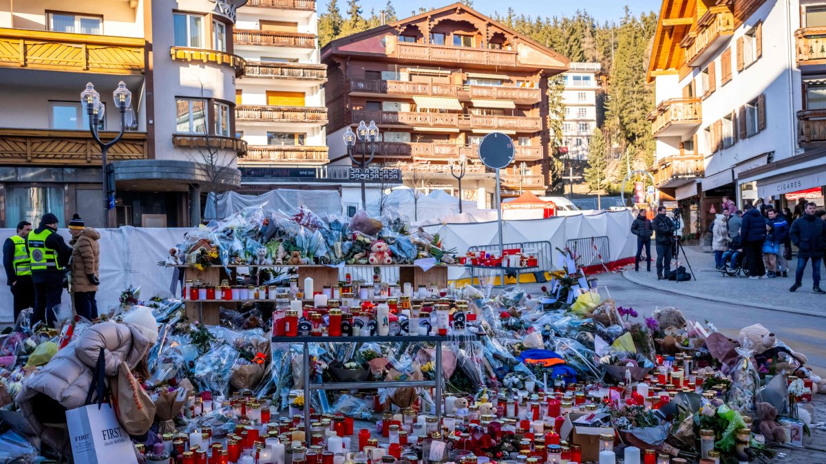 A mourner lays a flower bouquet at a makeshift memorial near the Constellation bar in honor of the victims of the fire that ripped through the venue in the luxury Alpine ski resort on New Year's Eve, in Crans-Montana, Switzerland, Jan. 4, 2026. (AFP Photo)