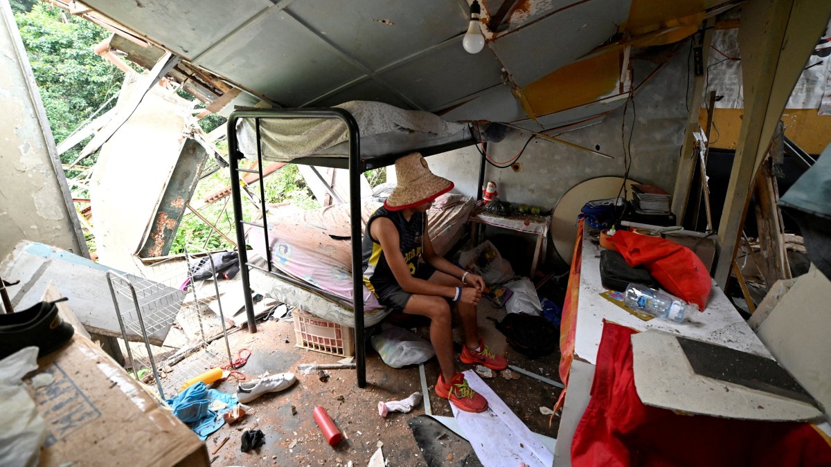 Maikel Linares, nephew of Carlos Bracho, salvages belongings from the rubble after a U.S. airstrike destroyed a TV and telephone tower that collapsed onto his home, killing a neighbor and injuring her daughter in the same attack, according to resident Carlos Bracho, in El Hatillo, on the outskirts of Caracas, Venezuela. Jan. 4, 2026. (Reuters Photo)