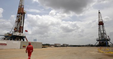 An oilfield worker walks next to drilling rigs at an oil well operated by Venezuela's state oil company PDVSA, in the oil-rich Orinoco belt, near Morichal, the state of Monagas, Venezuela, April 16, 2015. (Reuters File Photo)