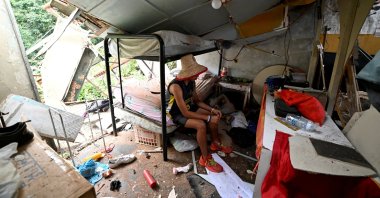 Maikel Linares, nephew of Carlos Bracho, salvages belongings from the rubble after a U.S. airstrike destroyed a TV and telephone tower that collapsed onto his home, killing a neighbor and injuring her daughter in the same attack, according to resident Carlos Bracho, in El Hatillo, on the outskirts of Caracas, Venezuela. Jan. 4, 2026. (Reuters Photo)