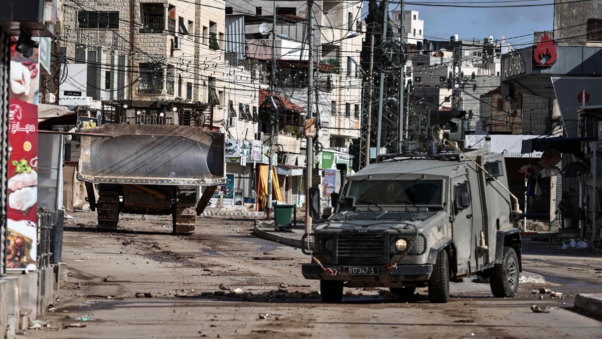 Military vehicles drive through a street during an Israeli army raid in the Palestinian village of Qabatiya, in the Israeli-occupied West Bank, Dec. 27, 2025. (AFP File Photo)