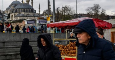 People walk past the counter of a traditional Turkish bagel "simit" street vendor, Eminönü, Istanbul, Türkiye, Dec. 27, 2025. (AFP Photo)