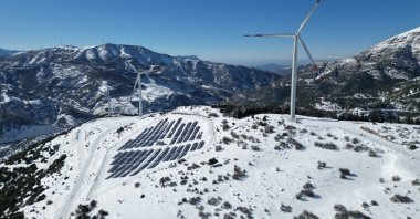 Wind turbines and a solar plant are seen against a backdrop of the Amanos Mountains, Osmaniye, southeastern Türkiye, Jan. 3, 2026. (AA Photo)