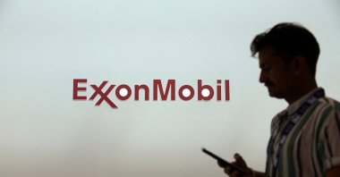 A man walks past a logo of ExxonMobil during the annual energy industry event Abu Dhabi International Petroleum Exhibition and Conference (ADIPEC) in Abu Dhabi, United Arab Emirates, Nov. 3, 2025. (Reuters Photo)