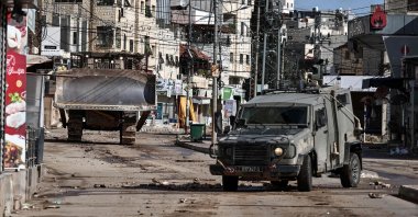 Military vehicles drive through a street during an Israeli army raid in the Palestinian village of Qabatiya, in the Israeli-occupied West Bank, Dec. 27, 2025. (AFP File Photo)