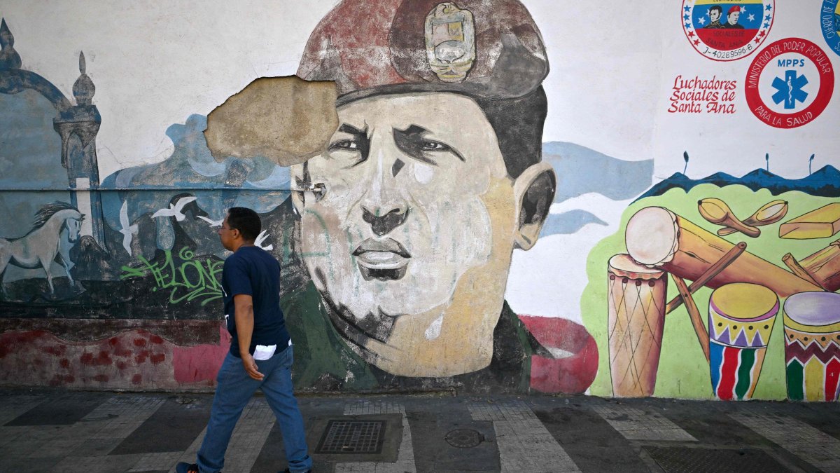 A man walks next to a mural of late Venezuelan president Hugo Chavez in Caracas, Venezuela, Jan. 5, 2026. (AFP Photo)