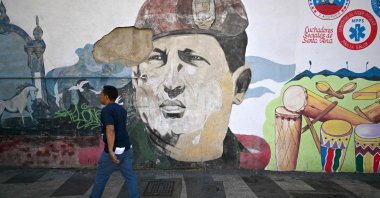 A man walks next to a mural of late Venezuelan president Hugo Chavez in Caracas, Venezuela, Jan. 5, 2026. (AFP Photo)