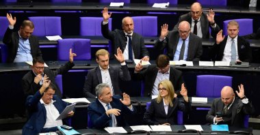Markus Frohnmaier (R), parliamentary group vice-leader of the far-right Alternative for Germany (AfD) party, AfD MP Stephan Brandner (L) as well as other AfD MPs vote with raised hands during a debate at the Bundestag (lower house of parliament), Dec.19, 2025. (AFP Photo)