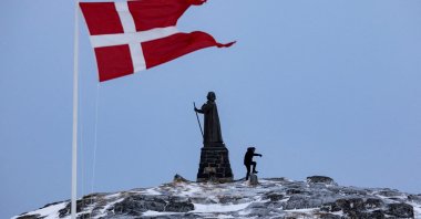 A man walks as Danish flag flutters next to Hans Egede Statue ahead of a March 11 general election in Nuuk, Greenland, March 9, 2025. (Reuters File Photo)