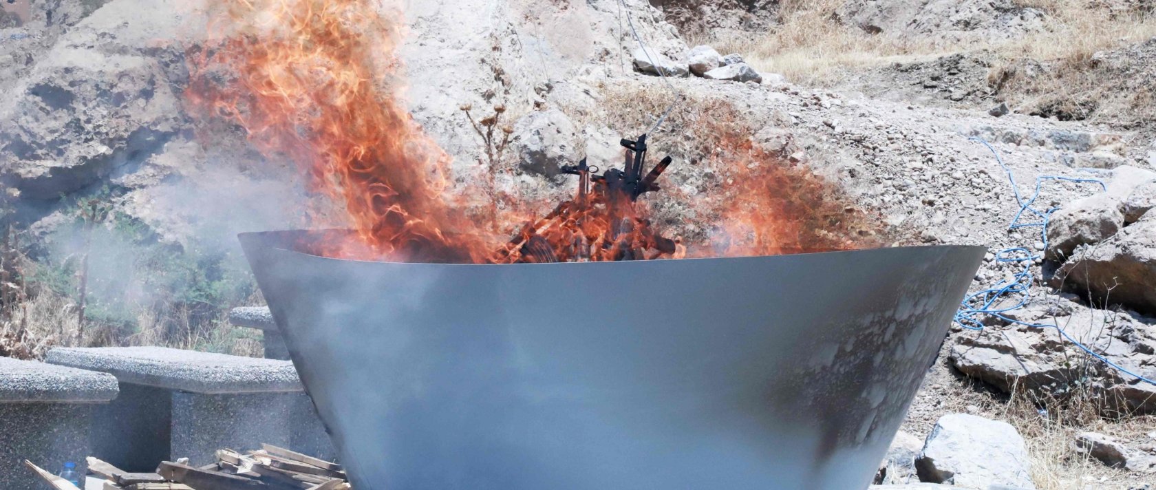A pit filled with weapons is set on fire by the PKK during a ceremony, Sulaimaniyah, Iraq, July 11, 2025. (AFP Photo)