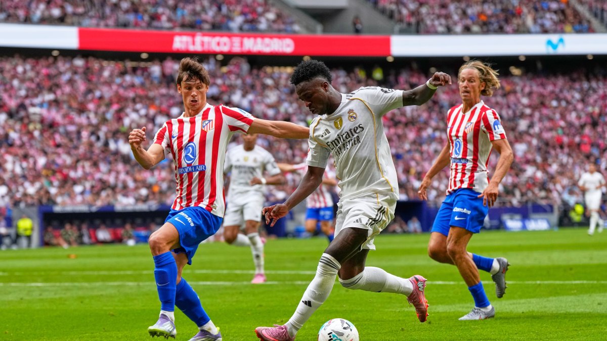 Real Madrid's Vinicius Junior (C) vies for the ball with Atletico Madrid's Robin Le Normand during the La Liga match between Atletico Madrid and Real Madrid at Metropolitano stadium, Madrid, Spain, Sept. 27, 2025. (AP Photo)