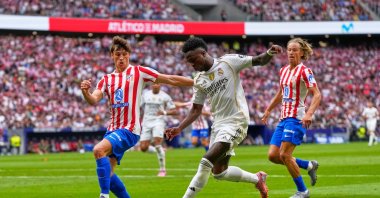Real Madrid's Vinicius Junior (C) vies for the ball with Atletico Madrid's Robin Le Normand during the La Liga match between Atletico Madrid and Real Madrid at Metropolitano stadium, Madrid, Spain, Sept. 27, 2025. (AP Photo)