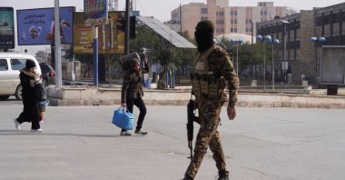 A member of the Syrian army walks in the street as civilians leave amid clashes with the YPG terrorist group, Aleppo, Syria, Jan. 7, 2026. (Reuters Photo)