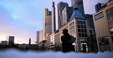 A person walks on a square in the banking district before sunrise, Frankfurt, Germany, Jan. 7, 2026. (AFP Photo)