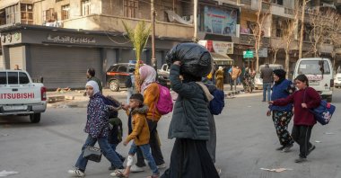 People carry their belongings as they flee Aleppo, Syria, Jan. 7, 2026. (EPA Photo)
