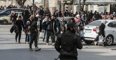 A member of the security forces stands guard as residents flee the Ashrafieh neighbourhood in Aleppo, Syria, Jan. 7, 2026. (AFP Photo)