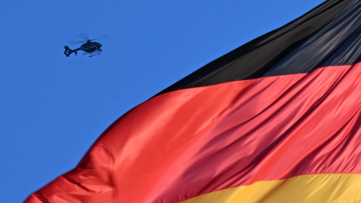 A helicopter of the German police is seen hovering over a German national flag at the Reichstag building that houses the Bundestag (lower house of parliament) in Berlin, Germany, Dece. 15, 2025. (AFP Photo)