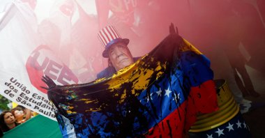 A man wears a mask depicting U.S. President Donald Trump during a protest against U.S. strikes on Venezuela and the capture of its President Nicolas Maduro, Sao Paulo, Brazil, Jan. 5, 2026. (Reuters Photo)