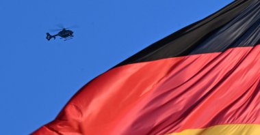 A helicopter of the German police is seen hovering over a German national flag at the Reichstag building that houses the Bundestag (lower house of parliament) in Berlin, Germany, Dece. 15, 2025. (AFP Photo)